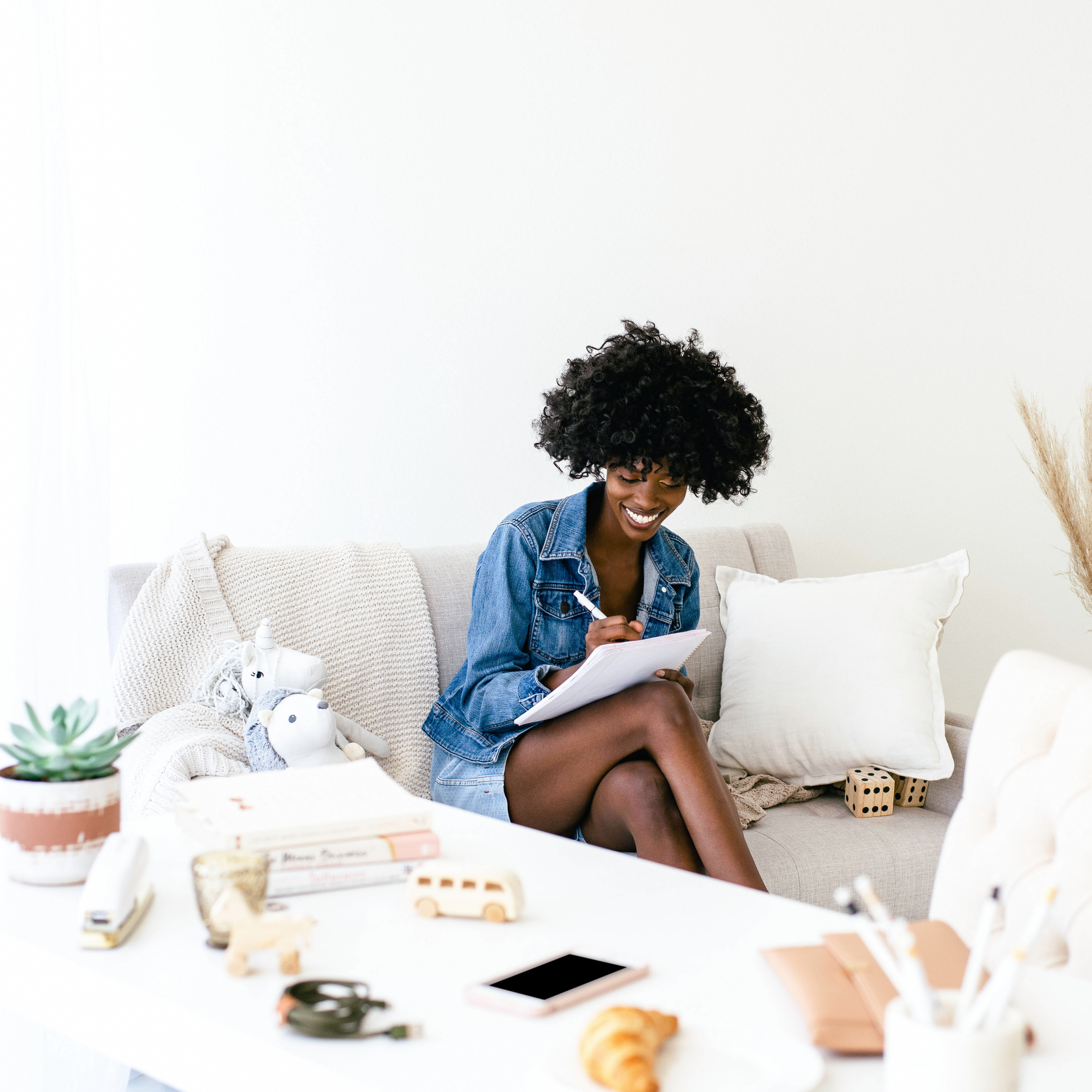 Black woman sitting down and journaling