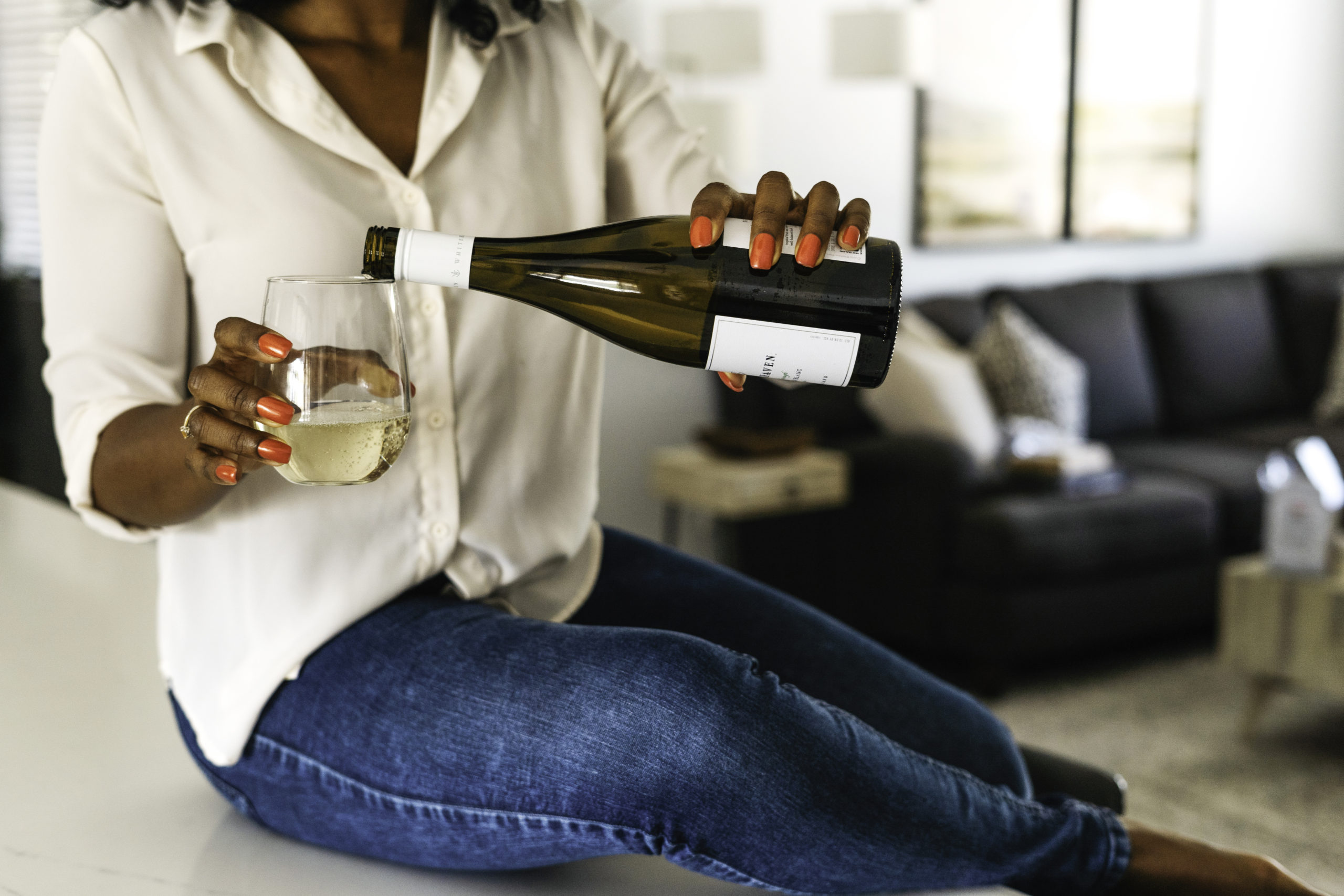 black-lady-sitting-on-the-floor-and-pouring-a-glass-of-wine