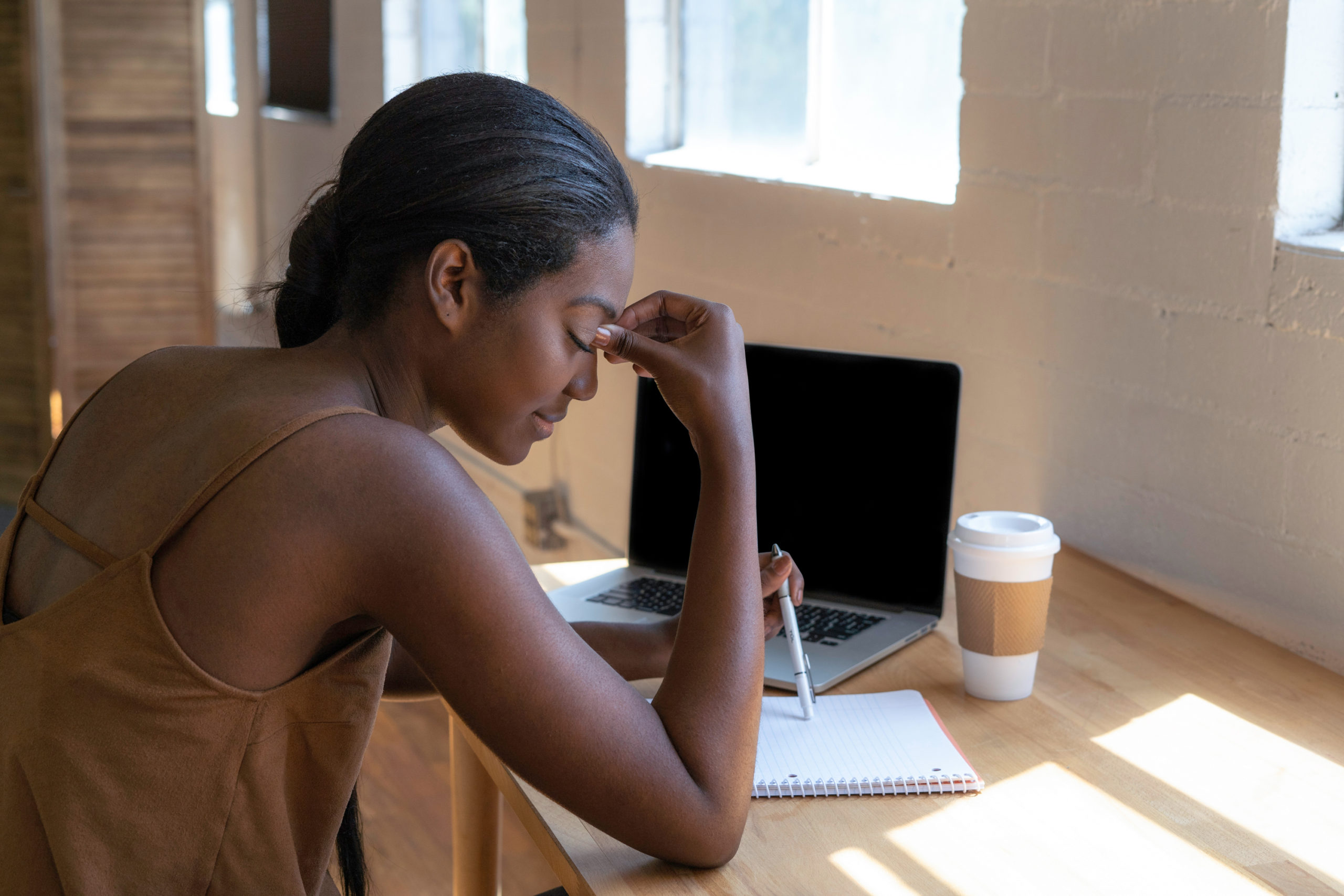 black-lady-wearing-a-brown-top-sitting-down-and-looking-stressed