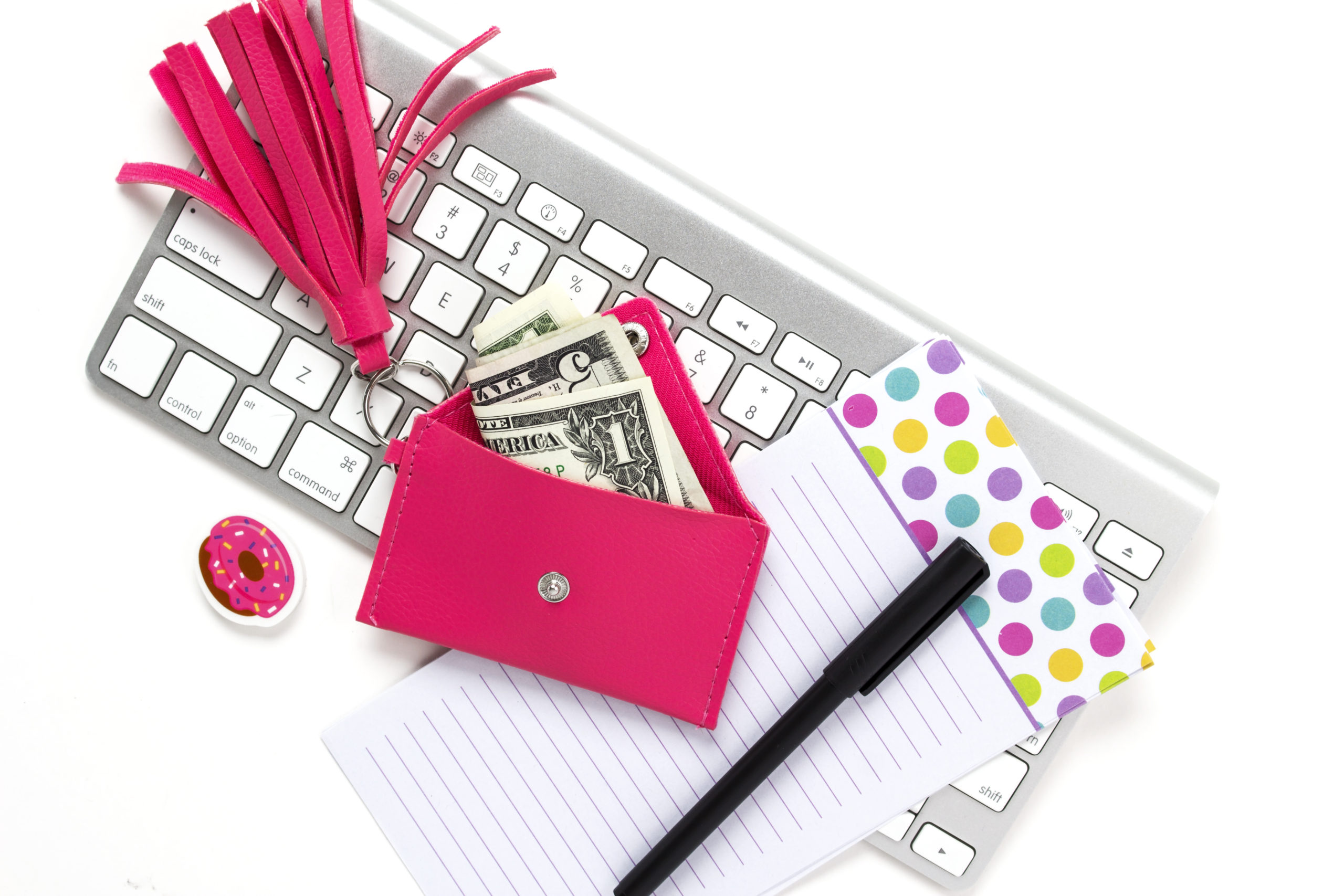 Dollar-note-in-a-pink-purse-on-a-key-board-and-white-paper-with-black-pen