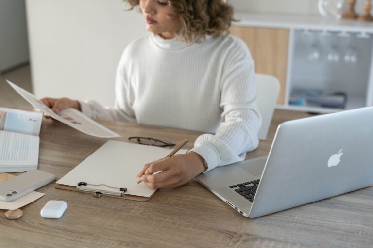white-caucasian-lady-working-on-a-desk-with-a-laptop-ontop