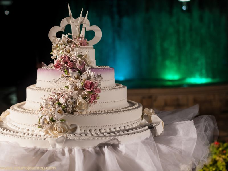 three step white wedding cake with many clours flowers