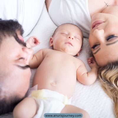 mum-and-dad-lying-on-the bed-with a-sleeping-baby